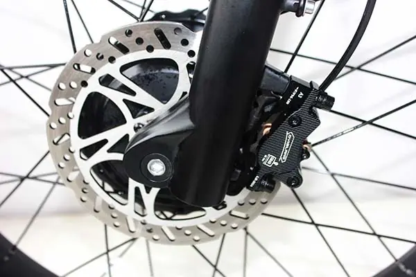 A person performing maintenance on an e-bike's brakes