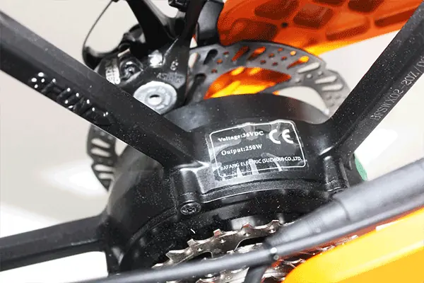 A speed sensor mounted on the e-bike's frame near the wheel's spokes.
