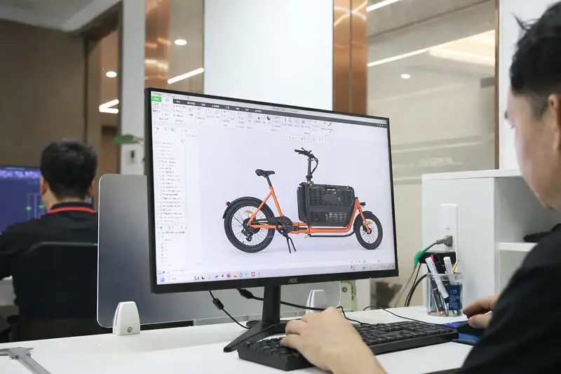 An engineer reviewing a 3D model of a cargo e-bike frame.