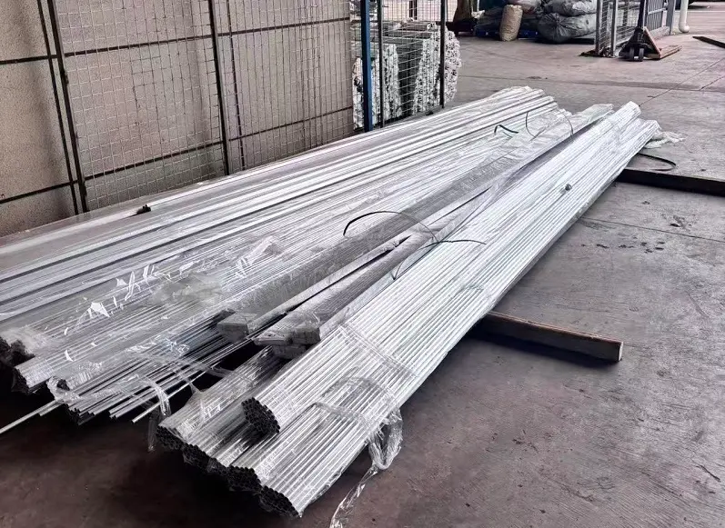 A factory floor showing both traditional tube stock and complex hydroforming molds