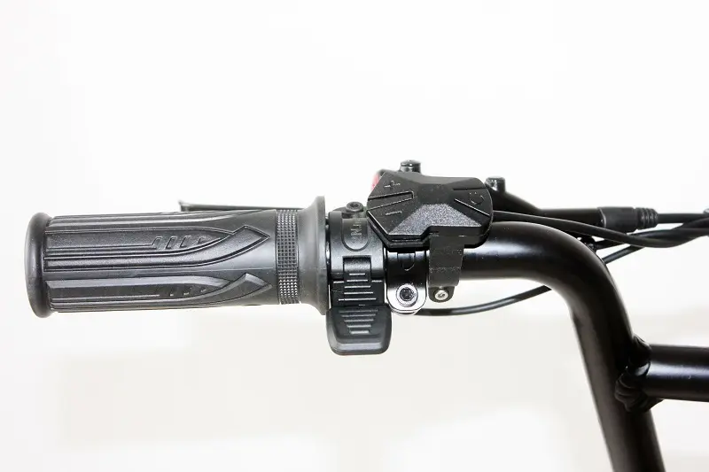 A close-up of a thumb throttle on a city e-bike handlebar