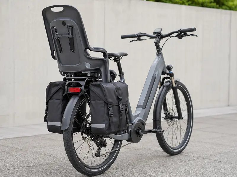Versatile E-Bike Rack An e-bike rear rack showing compatibility with both a child seat and pannier bags.